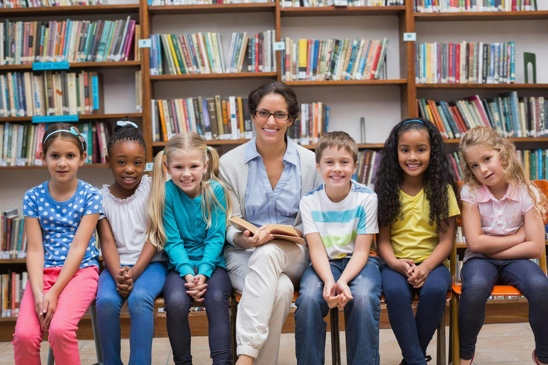 Teacher posing with her reading students in the library