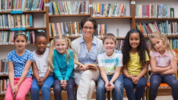 Teacher posing with her reading students in the library